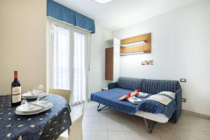 uma sala de estar com um sofá azul e uma mesa em We Home - PALESTRINA17 - Riccione sul mare em Riccione