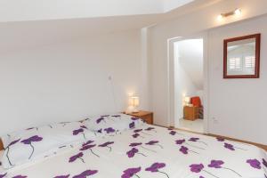 Un dormitorio con una cama con flores púrpuras. en Apartment Larica, en Dubrovnik