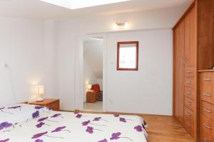 a bedroom with a bed with purple flowers on it at Apartment Larica in Dubrovnik