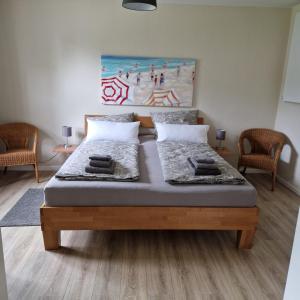 um quarto com uma cama com duas cadeiras e um quadro em Ferienwohnung Goldenitz II em Warlitz