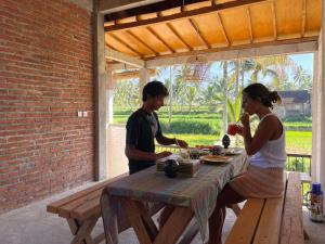特特巴图MyHome - Lombok的坐在野餐桌上的男人和女人