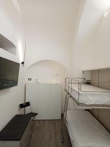 a white room with two bunk beds in it at Neruda Chic House Sant'Angelo in Sant'Angelo D'Ischia