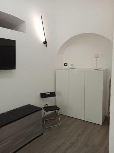 a white room with a tv and a chair at Neruda Chic House Sant'Angelo in Sant'Angelo D'Ischia