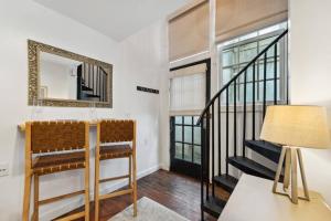 a living room with a staircase and a mirror at Exclusive Open Loft in Downtown Charleston in Charleston