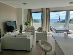 Μια τηλεόραση ή/και κέντρο ψυχαγωγίας στο Luxury beachfront apartment with pool, sauna, fitness and gym in province Malaga, Andalusia