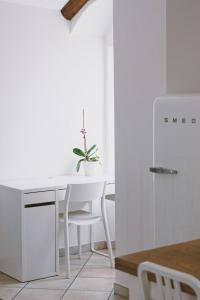 a white kitchen with a white desk and a table at Casa Lobe - Charming apartment in village centre in La Morra