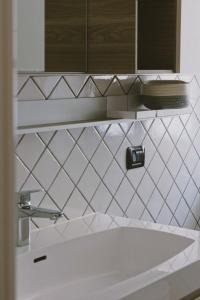 a white bathroom with a tub and a mirror at Casa Lobe - Charming apartment in village centre in La Morra