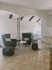 ein Wohnzimmer mit Stühlen, einem Tisch und Stühlen in der Unterkunft Casa Lobe - Charming apartment in village centre in La Morra