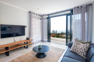 a living room with a couch and a large window at Luxury Bellagio 302 with Sea Views and Inverter in Durban