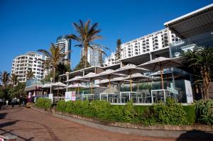 a hotel with tables and umbrellas in front of a building at Luxury Bellagio 302 with Sea Views and Inverter in Durban