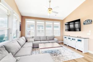 a living room with a couch and a flat screen tv at Vanodi Landing in North Topsail Beach