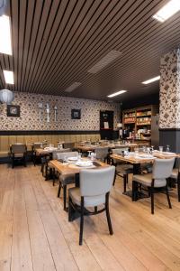 a dining room with wooden tables and white chairs at Turnhout City Hotel in Turnhout