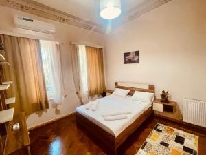 a bedroom with a bed in a room with windows at Vintage Home in Kutaisi