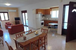 a kitchen and living room with a table and chairs at Tilos Pearl in Livadia +6 photos