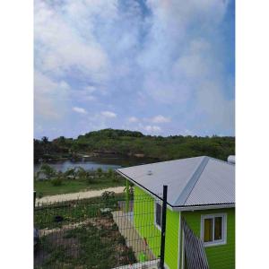 a green house with a view of a river at Les bungalows de Pipo 1 in Anse-Bertrand