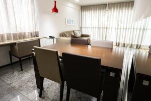 uma sala de estar com uma mesa de madeira e cadeiras em Nobile Residences Maria Frazão em Recife