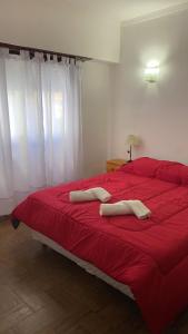 a red bed in a bedroom with white curtains at Hotel Hanna in Mar del Plata