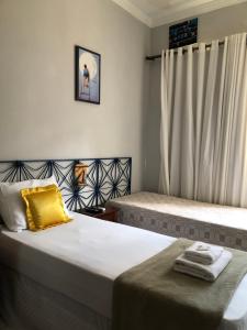 um quarto com duas camas e uma cortina em Pousada Recôncavo em São Félix