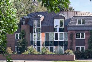 a large brick house with a black roof at Hotel Business & More SELF CHECK IN in Hamburg