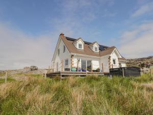 a house on top of a hill with grass at Beachview in Oldshoremore