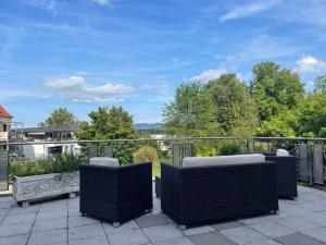 een patio met 3 stoelen op een balkon bij Fewo BOHO 110 qm mit Bergblick 3 min Bahnhof in Laufen