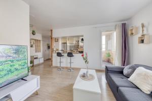 a living room with a couch and a tv at Next to Disneyland -Palm Spring in Torcy