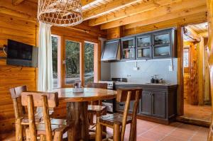 Una cocina con una mesa y sillas de madera. en BOG Torres del Bayo, en Villa La Angostura