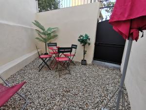 un patio con sillas, una mesa y una planta en Coquet 2 pièces entièrement rénové et climatisé, en Cannes