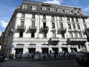 a large white building with balconies on a street at Easy Isola, for an easy stay in Milan