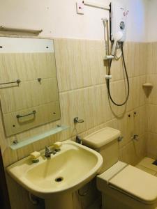 a bathroom with a sink and a toilet and a mirror at Komaligma villa by camrin Group 