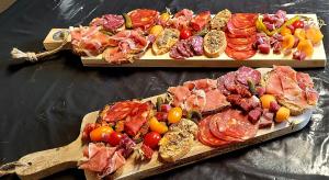 duas tábuas de corte com diferentes tipos de carnes e produtos hortícolas em La Maison de la Saye & SPA em Mios