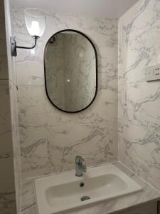 uma casa de banho com um lavatório e um espelho na parede em West Kensington em Londres