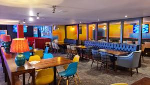 a restaurant with tables and chairs and a bar at Madaisy in Lossiemouth