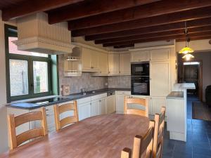 a kitchen with a wooden table and chairs in it at Holiday Home Slaghekhoeve in Nieuwkapelle
