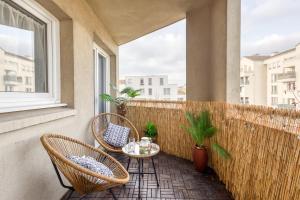 a balcony with two chairs and a table and a window at Next to Disneyland -Palm Spring in Torcy