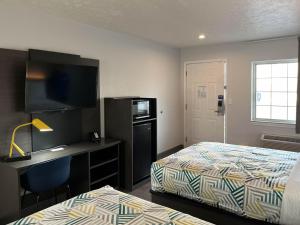 a hotel room with a bed and a desk with a computer at Motel 6-Lafayette, IN in Lafayette