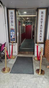 a hallway with red ribbon barriers in front of a building at Hôtel Aux Armes de Belgique in Lourdes
