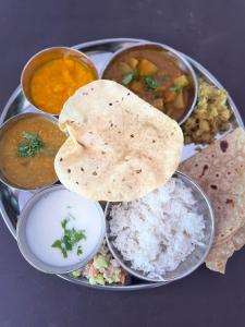 MTDC Vishwas Homestay, Kotawde, Ratnagiri في راتنجاري: طبق من الطعام مع الرز وأنواع مختلفة من الطعام