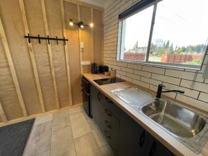 a small kitchen with a sink and a window at Te Anau Lakefront Backpackers in Te Anau