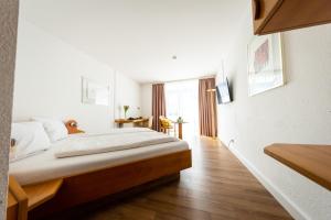 斯圖加特的住宿－CityHotel Feuerbach，一间卧室设有一张大床,铺有木地板