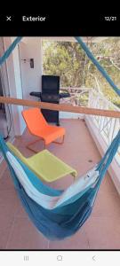 a hammock with a chair and a computer on a balcony at Juan Dolio Guababerry Resort in Juan Dolio