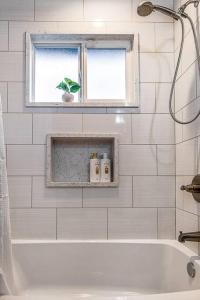 bagno con vasca, finestra e lavandino di Family and business friendly next to Newcastle a Newcastle