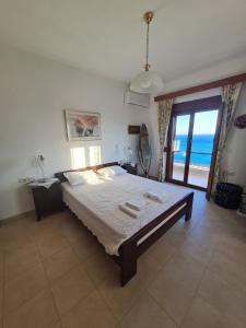 a bedroom with a bed with a view of the ocean at VILLA PETRINO in Tsoútsouros