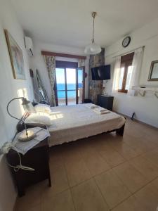 a bedroom with a bed with a view of the ocean at VILLA PETRINO in Tsoútsouros