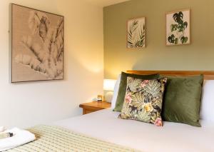 a bedroom with a bed with green pillows at Chapel Street Cottage in Coton in the Elms