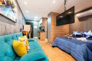 uma sala de estar com um sofá azul e uma televisão de ecrã plano em Rover Centro em São Paulo