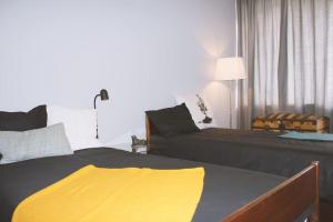 um quarto com 2 camas e um cobertor amarelo em Dorme em Porto