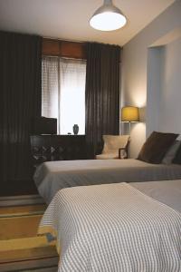 a hotel room with two beds and a window at Dorme in Porto