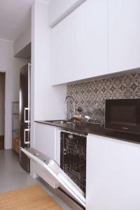 a kitchen with a sink and a stove top oven at Dorme in Porto