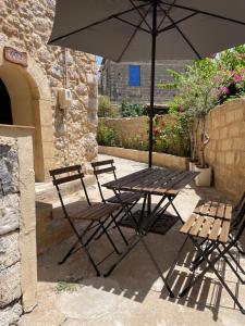 a table and chairs with an umbrella on a patio at Pyrgos Fassea Kardamyli in Kardamyli